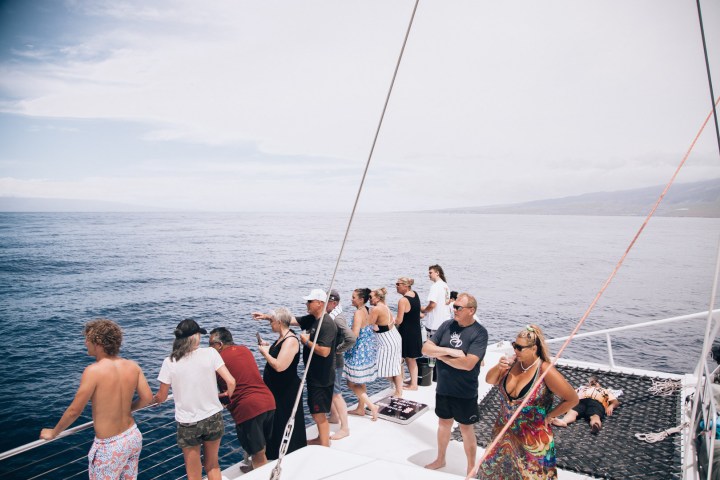 a group of people standing next to a body of water