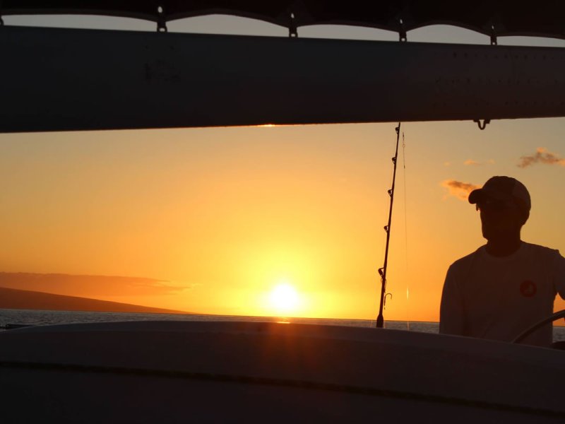 a man standing in front of a sunset