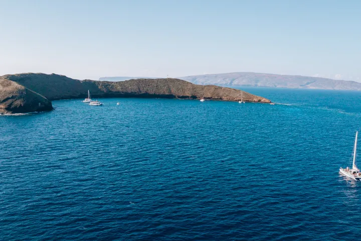 a small boat in a body of water with a mountain in the background