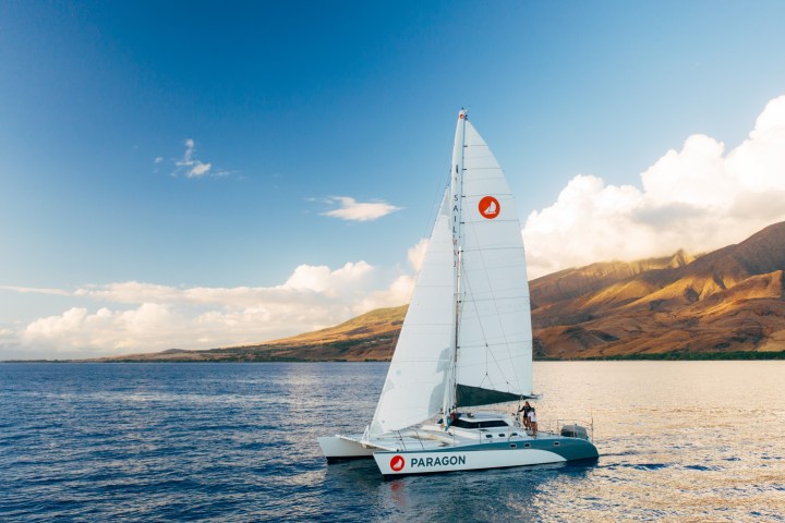 a small boat in a body of water with a mountain in the background