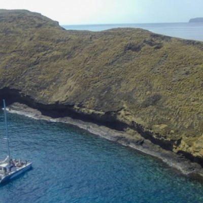 a small boat in a body of water with a mountain in the background