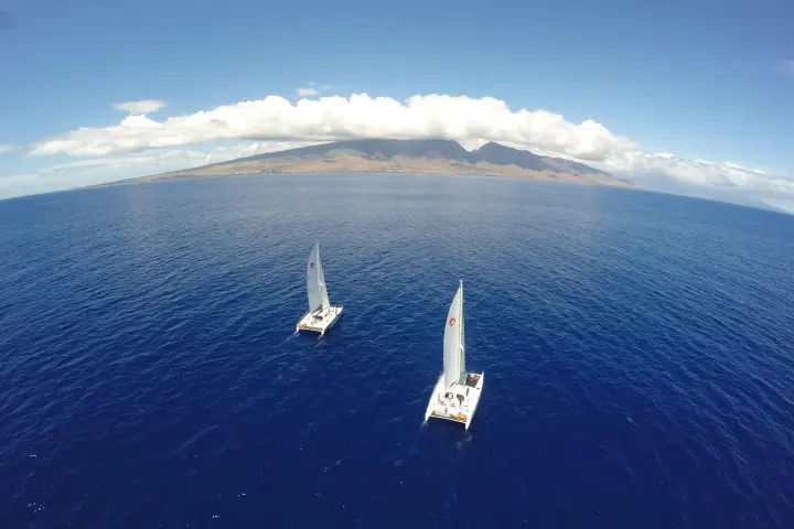 a plane flying over a body of water with a mountain in the background