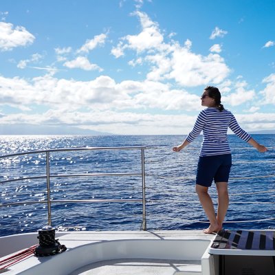 a person standing in front of a boat next to a body of water