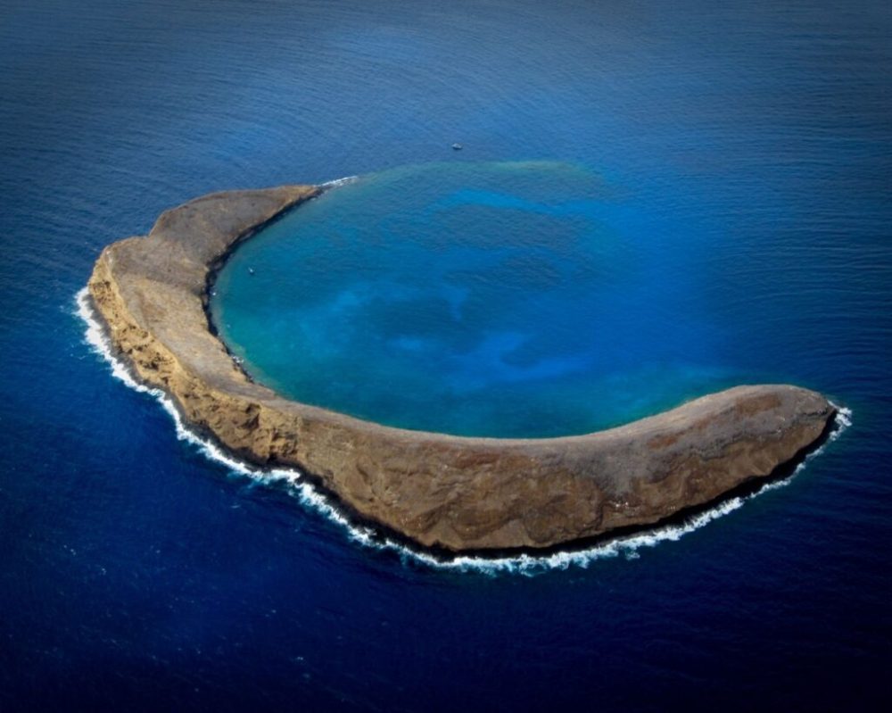 a body of water with Molokini in the background