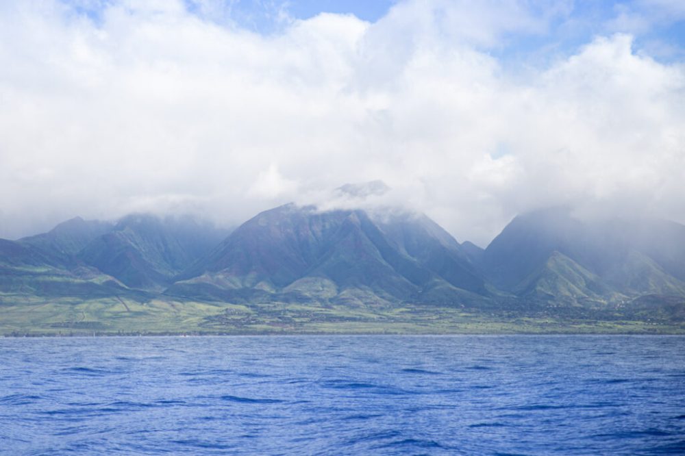 a large body of water with a mountain in the background