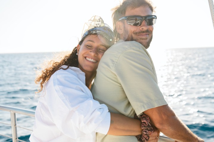 a man and a woman standing next to a body of water
