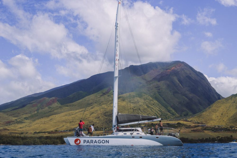 a small boat in a body of water with a mountain in the background