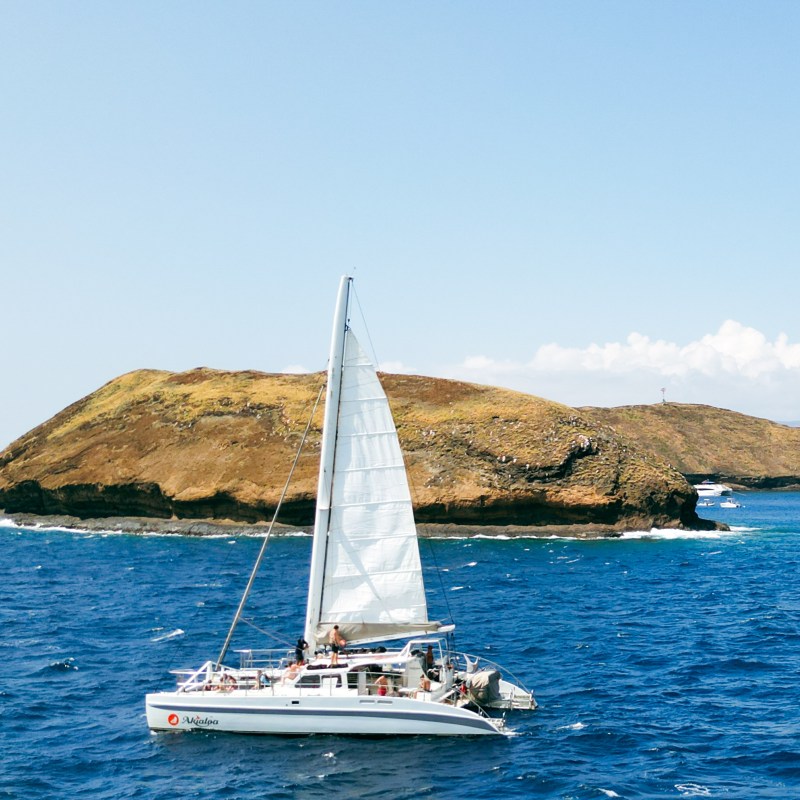 a small boat in a body of water with a mountain in the background