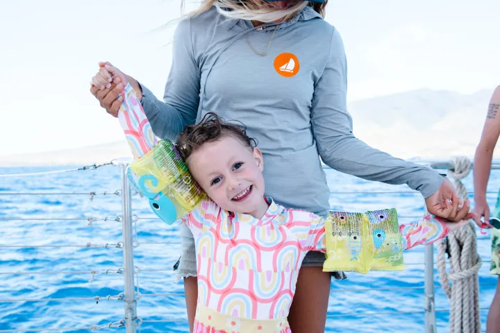 a person holding a baby in a body of water