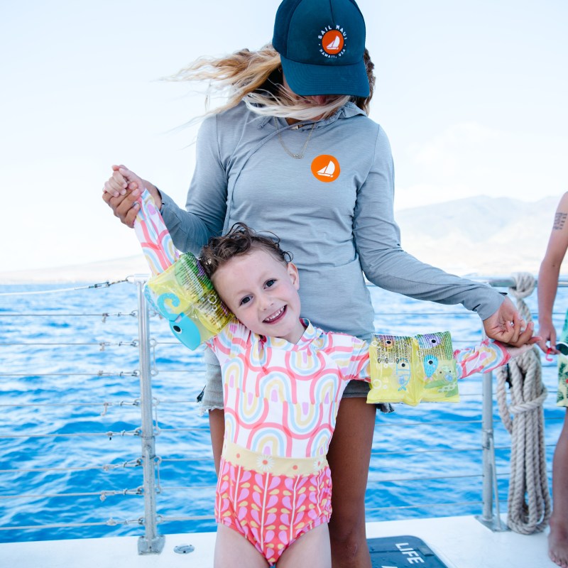 a person holding a baby in a body of water